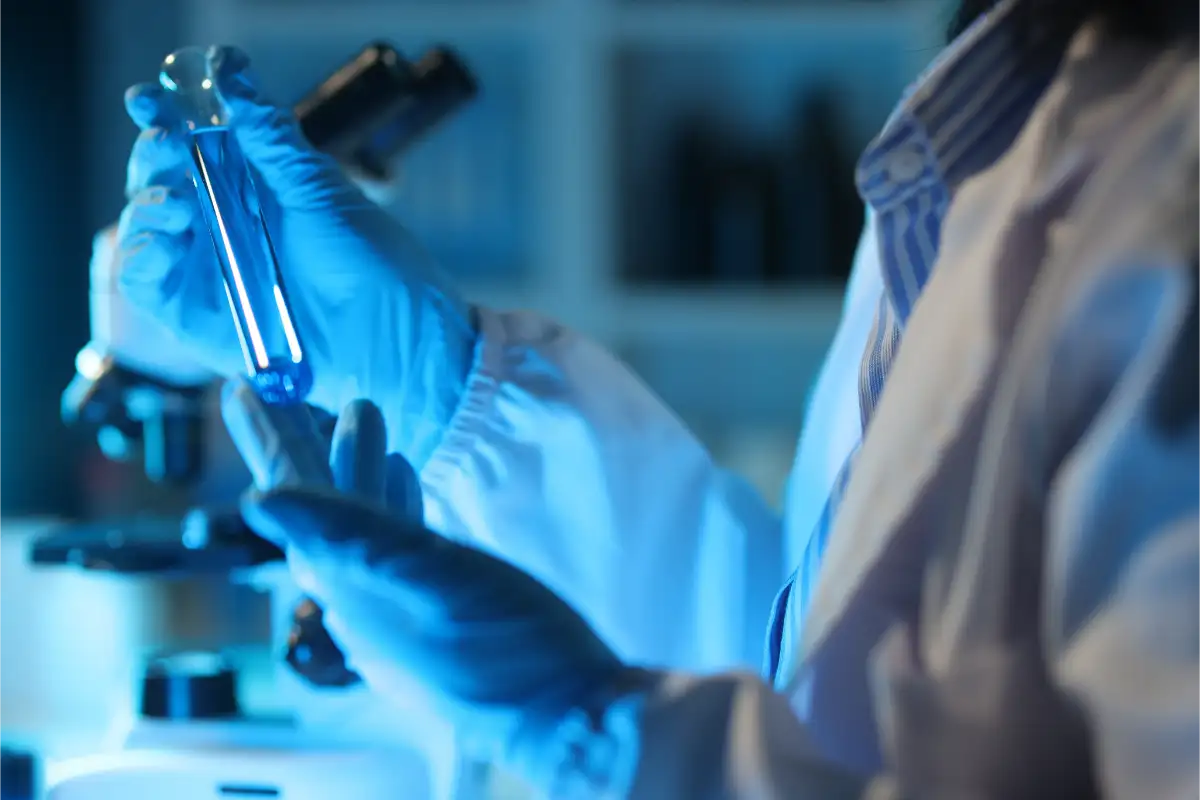 Medical Scientist Analyzing Test Tube With Blue Liquid In Laboratory
